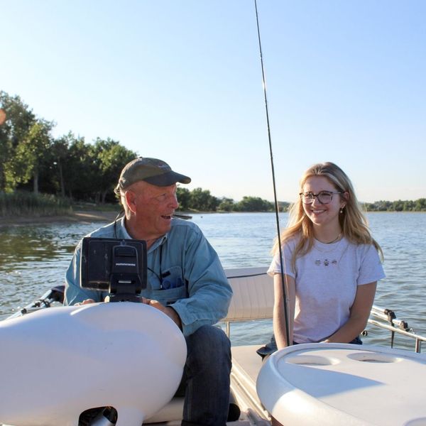 older man and younger girl fishing on boat