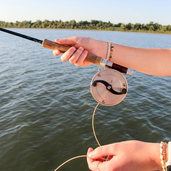 holding fishing rod up again water showing vintage reel holding fishing rod up again water showing vintage reel