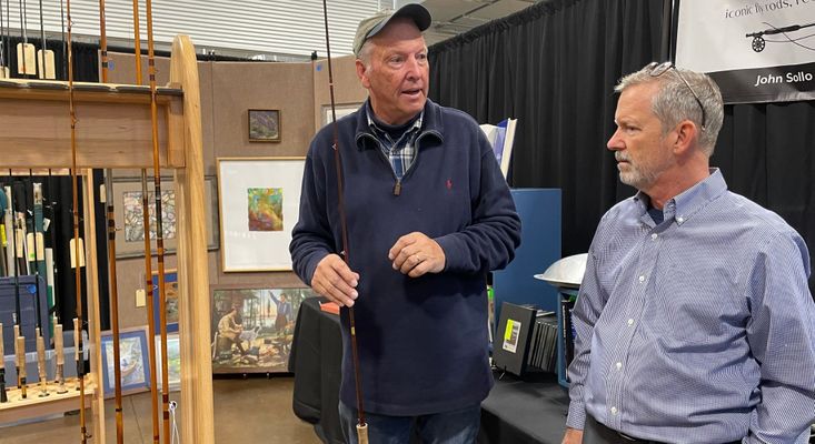 two men discussing vintage fishing rods