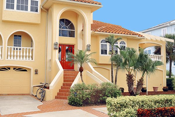 Image of a well manicured landscape in front of Florida style home