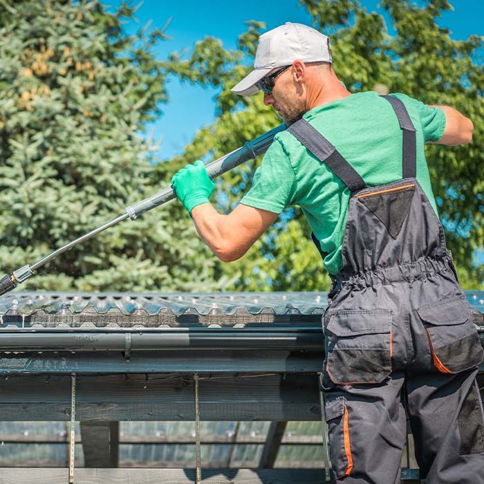 man power washing gutters