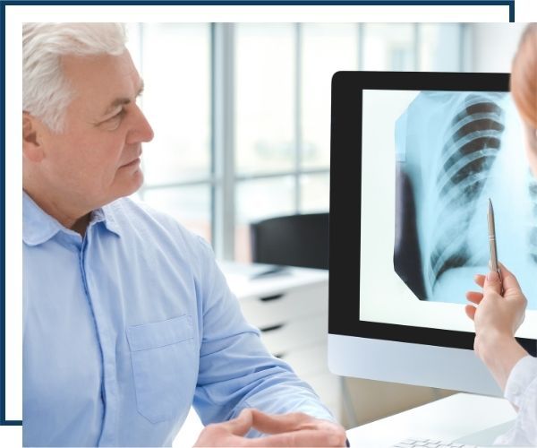 a doctor and older man looking at a chest xray
