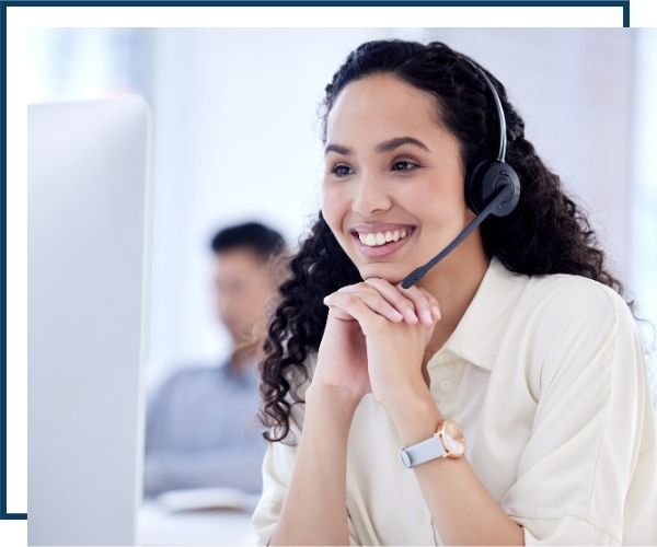 a happy woman in a headset in front of a computer