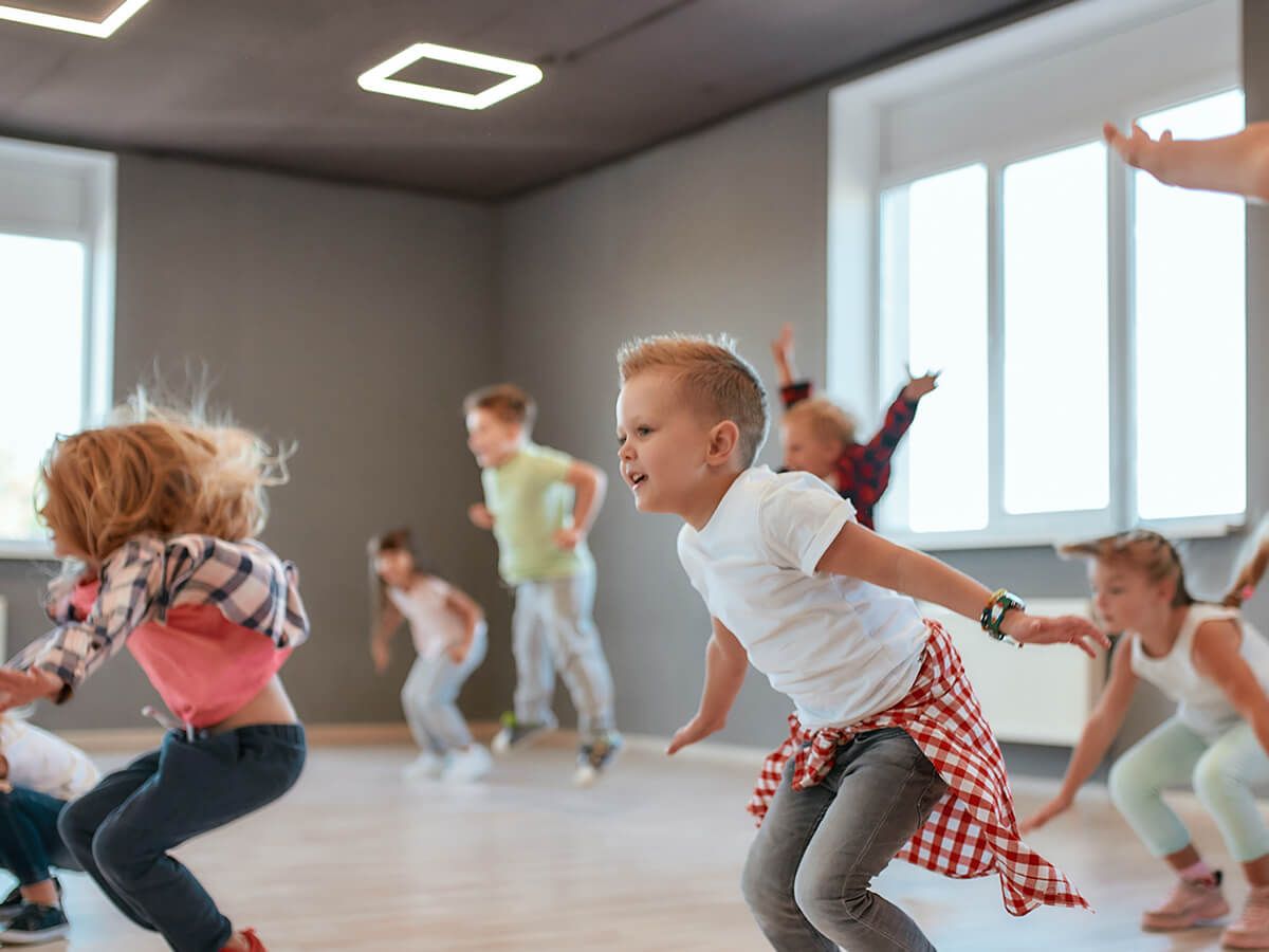Group of cute little boys and girls studying modern dance in studio.