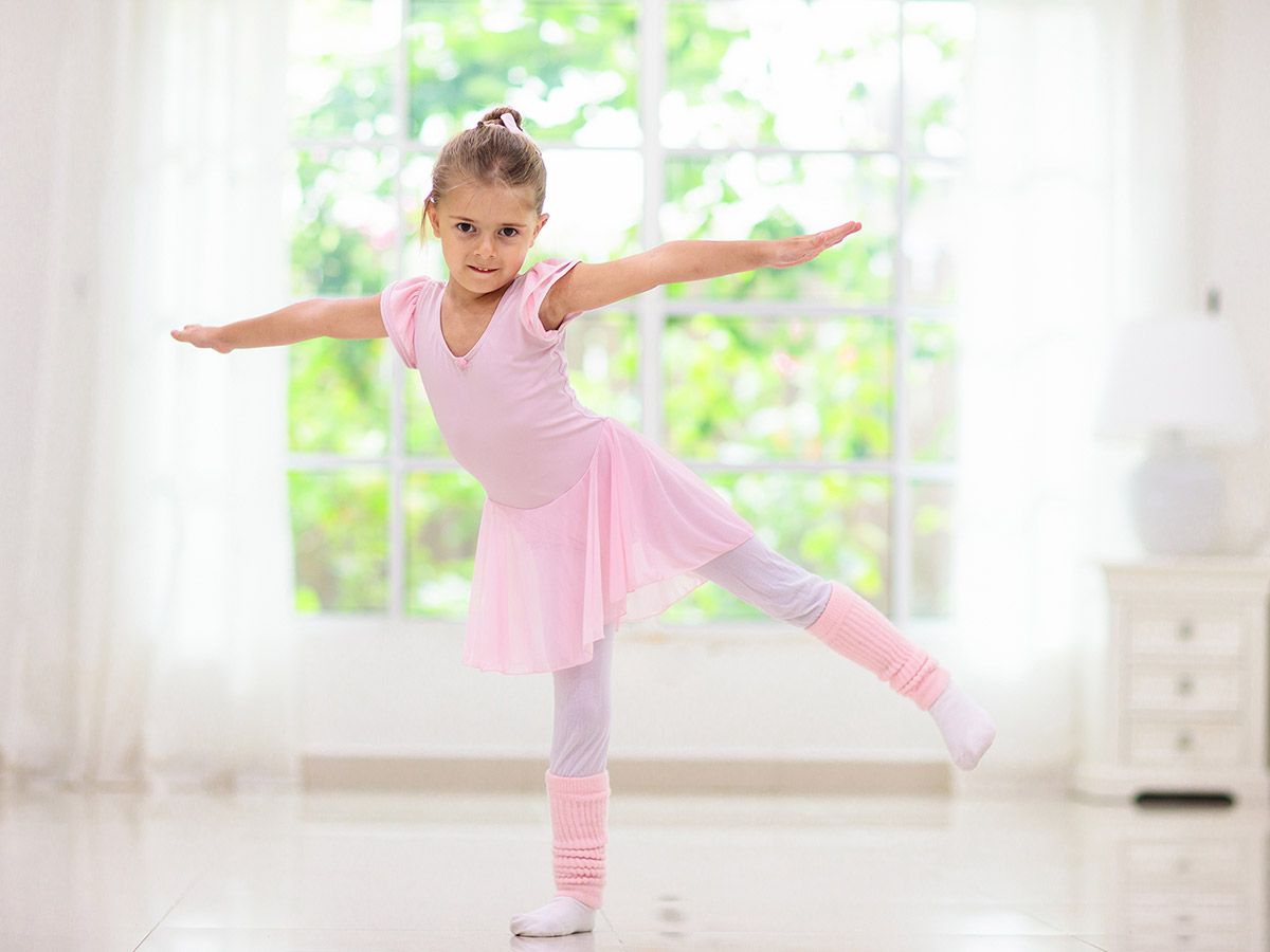 Cute girl in pink tutu and leotard learning to dance.