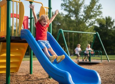 kid going down a slide on a playground