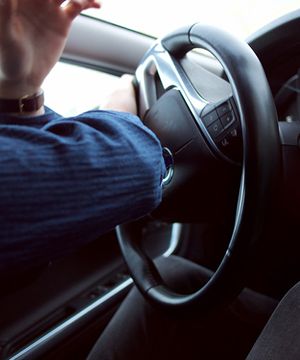 a person turning a steering wheel quickly