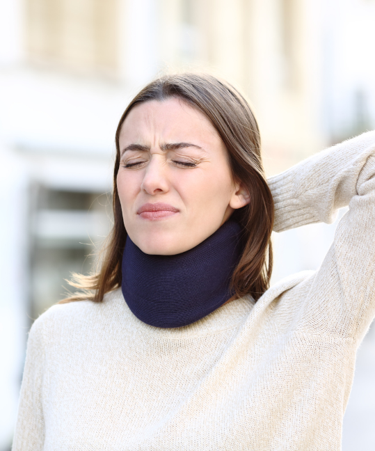 A woman wincing while wearing a neck brace