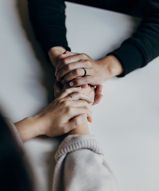 Two people holding each others' hands