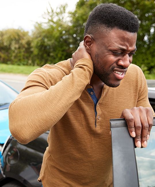 A man holding his neck after a car accident