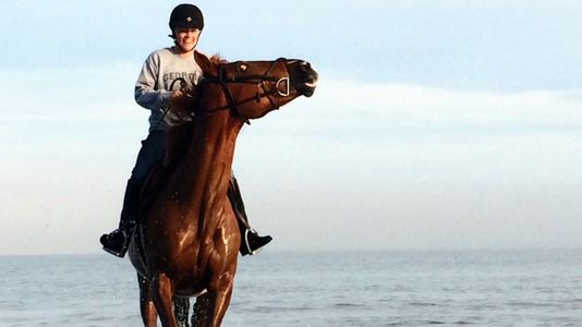 smiling girl riding horse