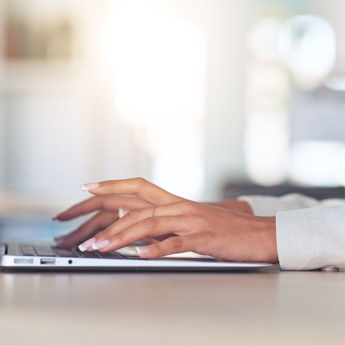 a professional woman typing on a laptop