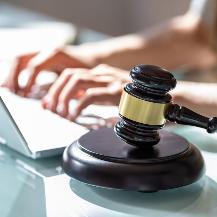 a person typing behind a gavel