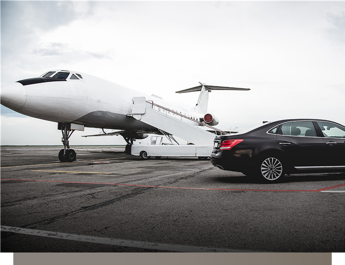 luxury car next to an airplane