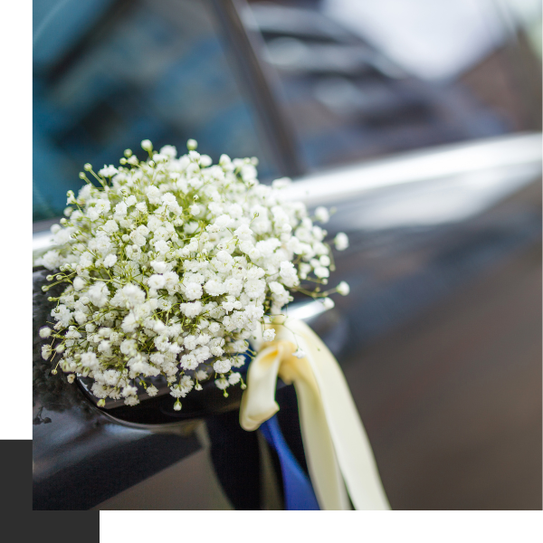 Limo with bouquet of baby's breath resting on rear view mirror