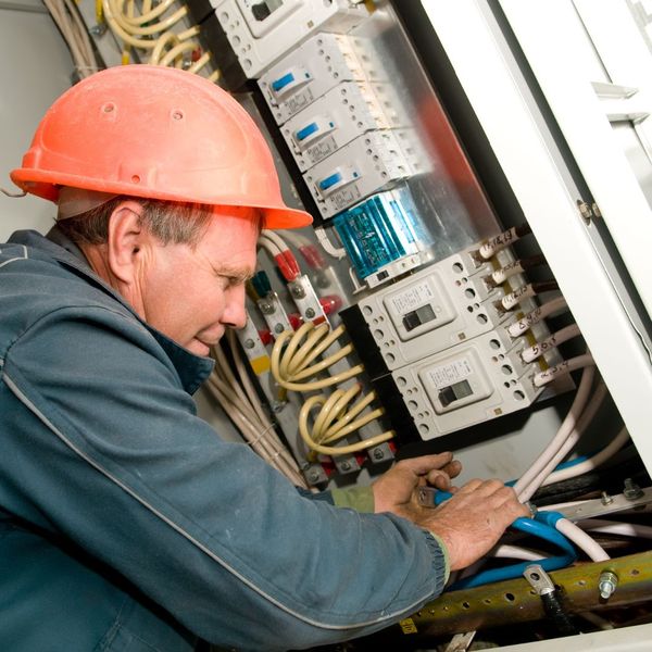 An electrician repairing large tube wiring