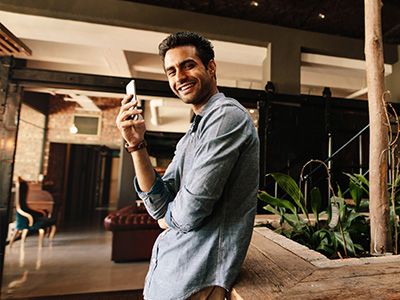 man smiling holding smart phone