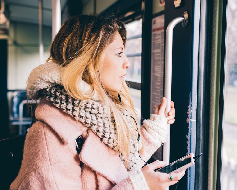 woman holding bar waiting to get off of bus