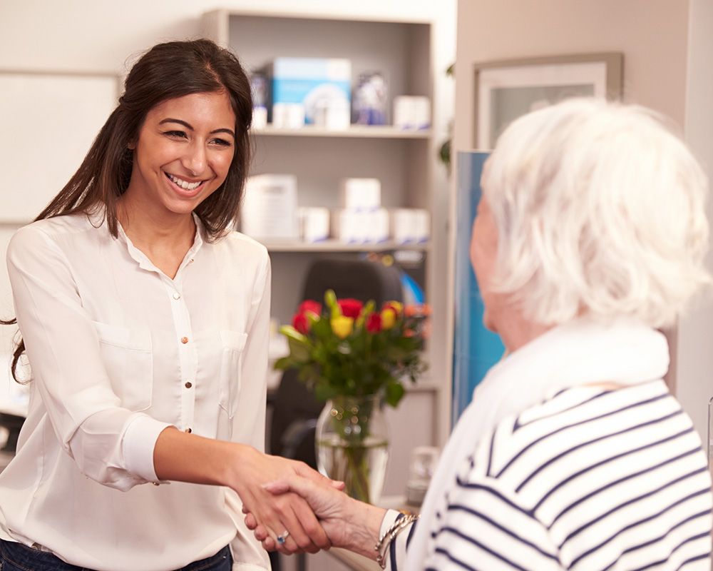 woman shaking hands with audiologist