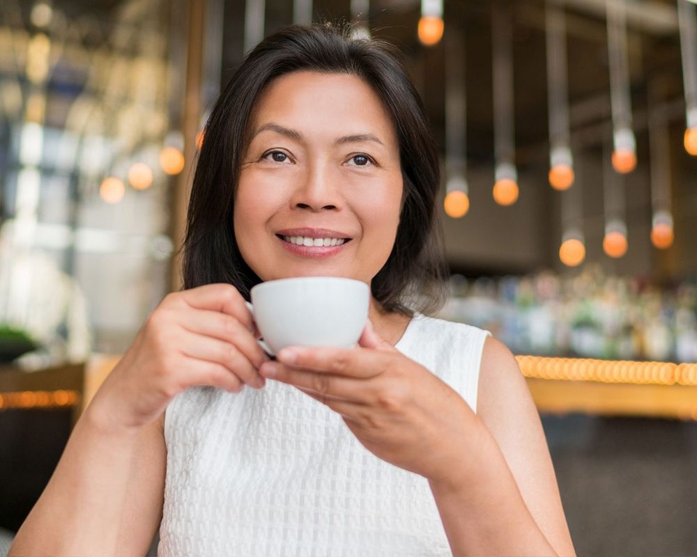 woman drinking coffee, smiling