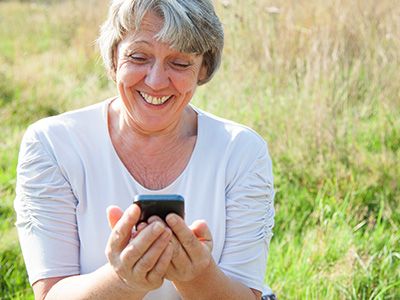 smiling woman looking at cell phone