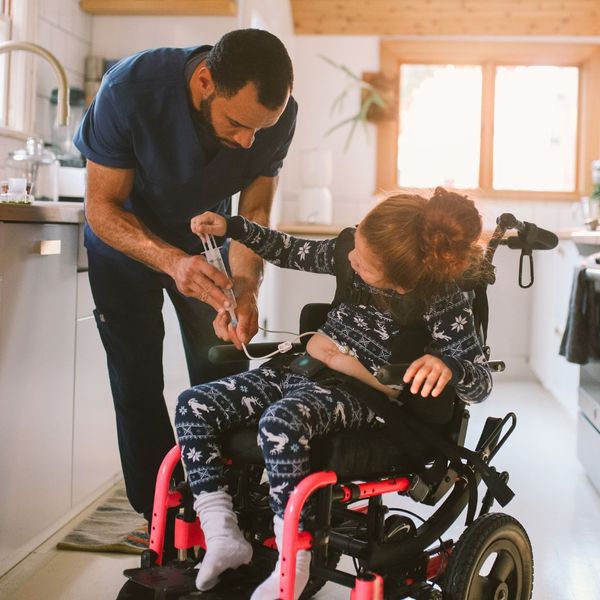 adult helping a person in a wheelchair