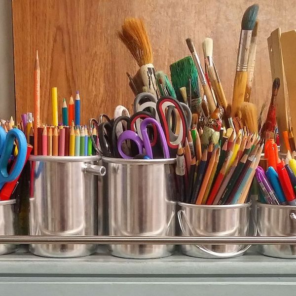 cups full of pencils, paint brushes and scissors