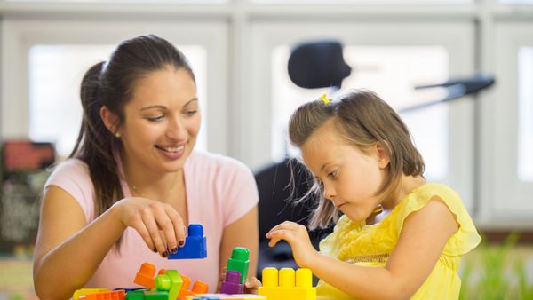caregiver playing blocks with child