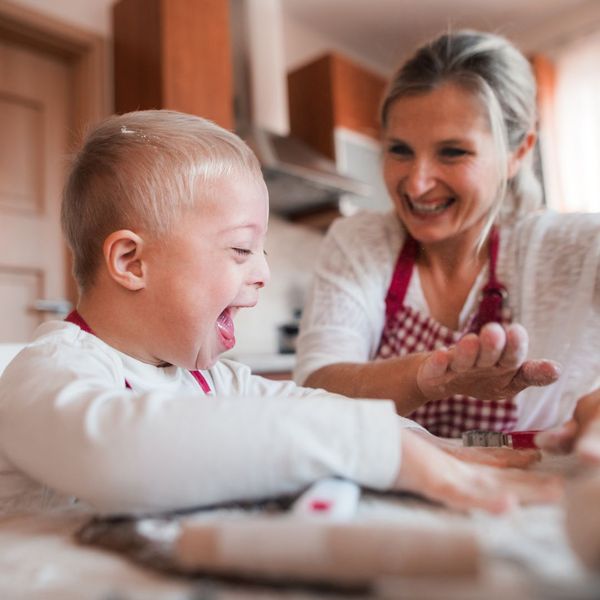 mom smiling while baking cookies with her son