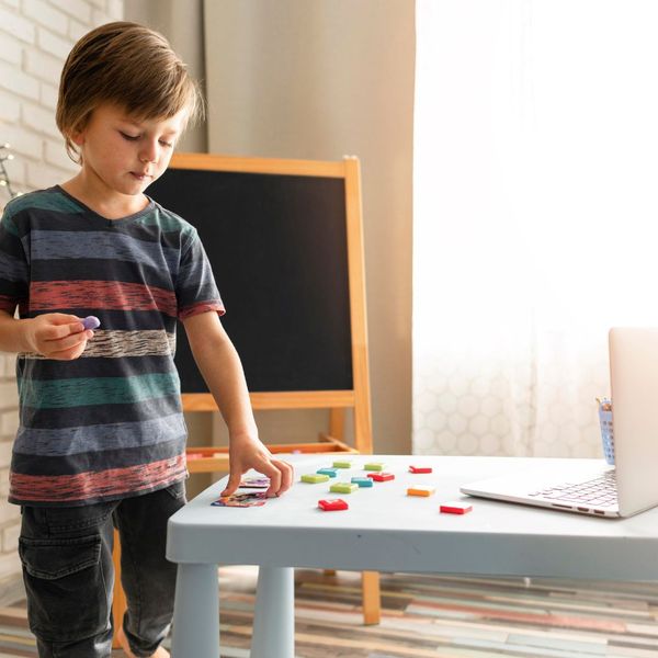 little boy putting playing with toys at a kid's table