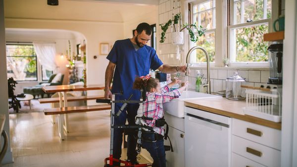 caregiver assisting special needs child with hand washing