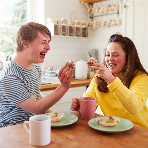 special needs adult eating in kitchen with care provider