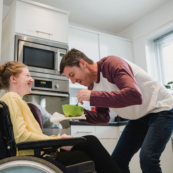 father feeding daughter with special needs