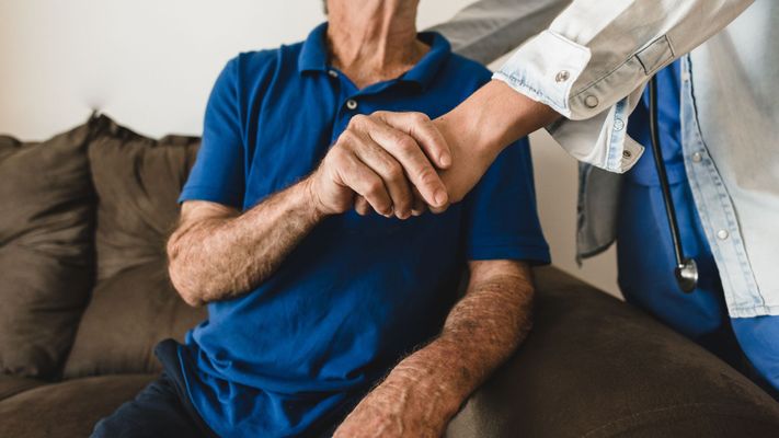 caregiver and patient holding hands