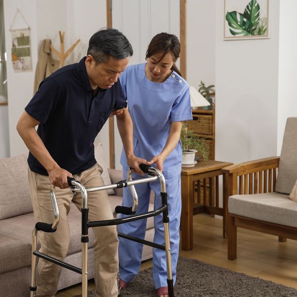 caregiver helping patient with walker