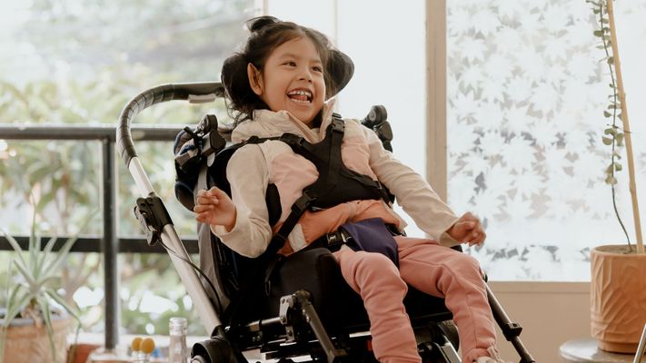 smiling girl with a disability in a wheelchair
