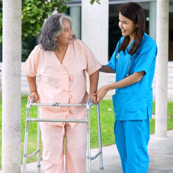 caregiver helping elderly woman on a walk