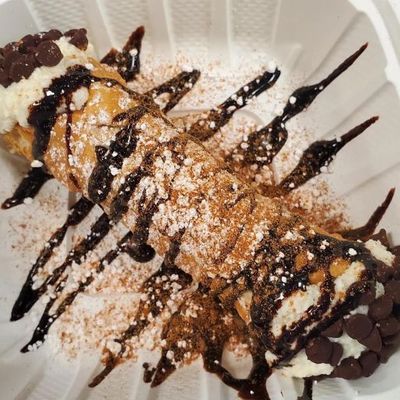 a cannoli drizzled with chocolate sauce