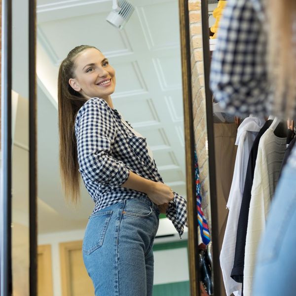 Woman trying on clothes in mirror