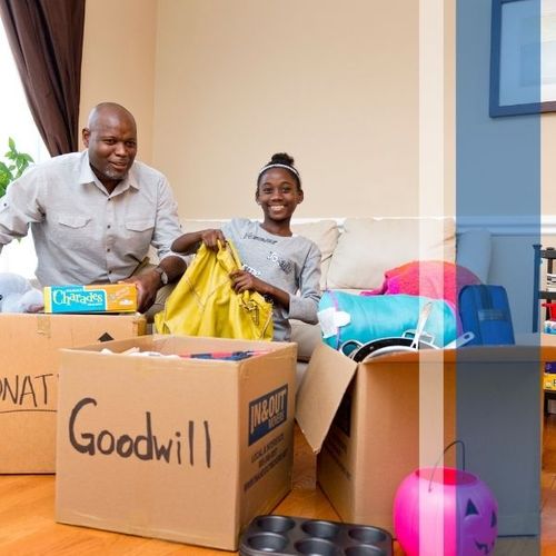 A young girl and her father filling donation boxes for Goodwill