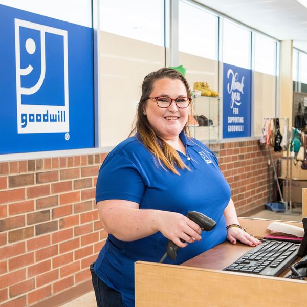 Goodwill employee at register smiling