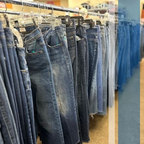 A rack of denim pants in a Goodwill store