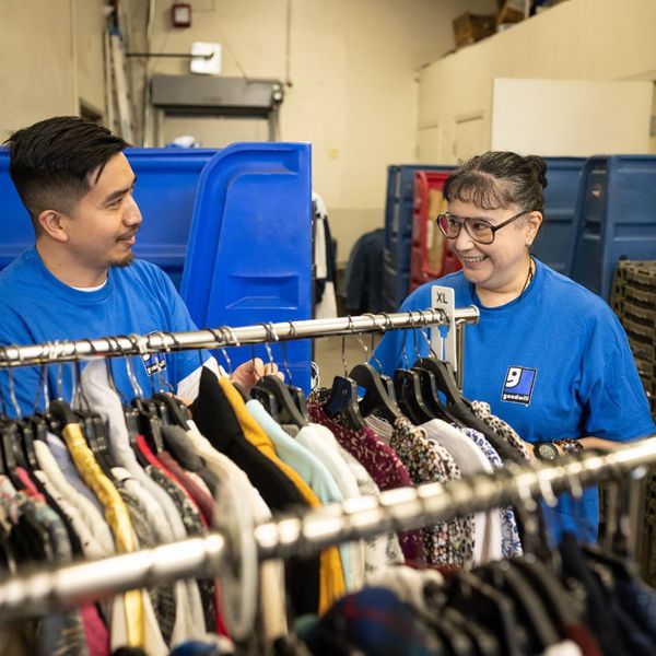 Two Goodwill employees sorting through clothes