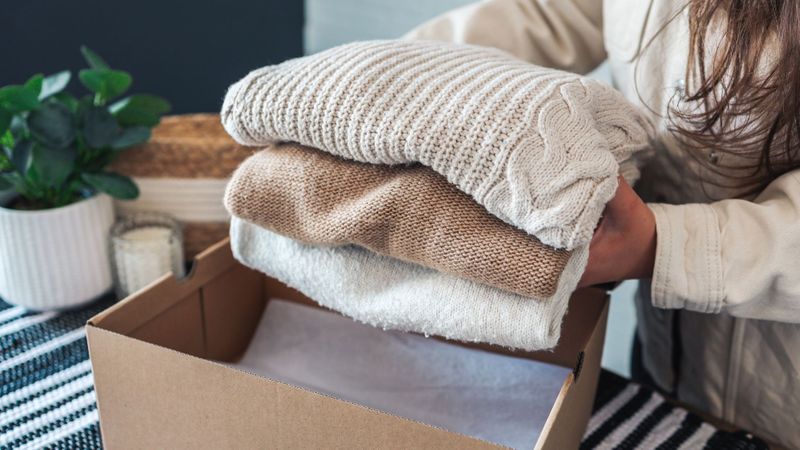 Putting folding sweaters and putting them into box