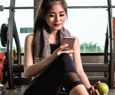 Image of a girl on a phone in a gym