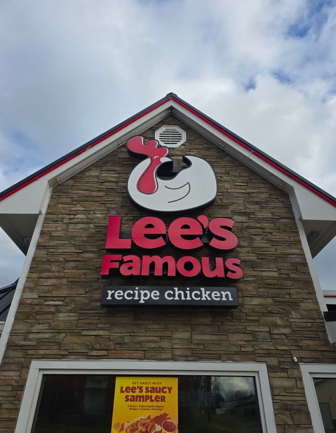 a sign for a chicken shop on the side of the building 1985183449220297338.jpg