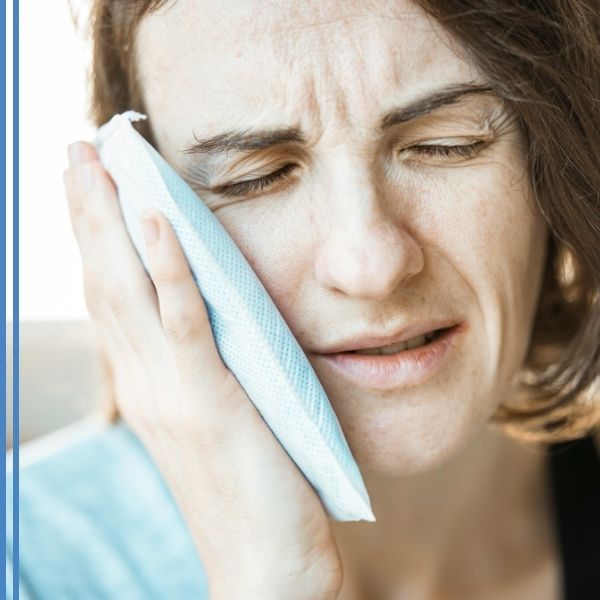 A woman icing a painful toothache