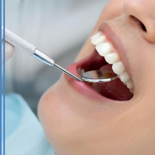 A dentist using a mirror to inspect a patient's teeth