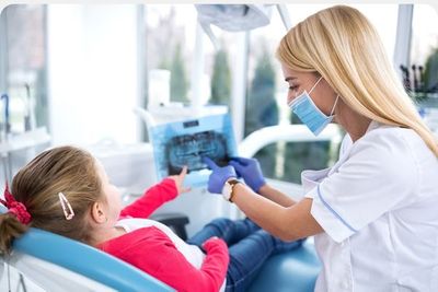 A woman dentist showing xrays to a young girl