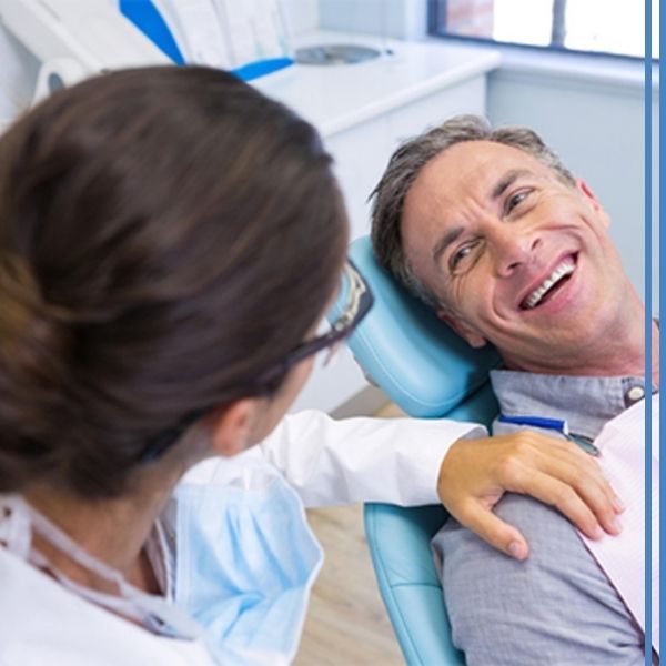 A dentist comforting a man at the dentist